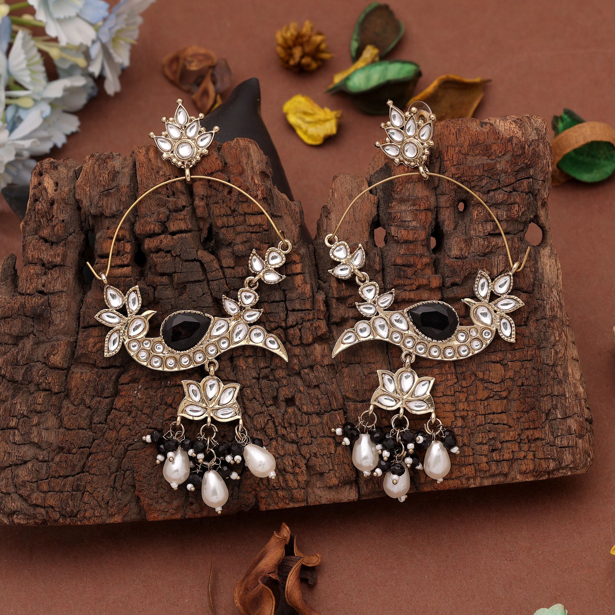A pair of oversized antique gold-plated hoop chandbali earrings adorned with multi-shaped Kundan stones, a large central faceted gemstone, and a dangling fringe of tiny black micro-beads paired with smooth white pearl droplets.