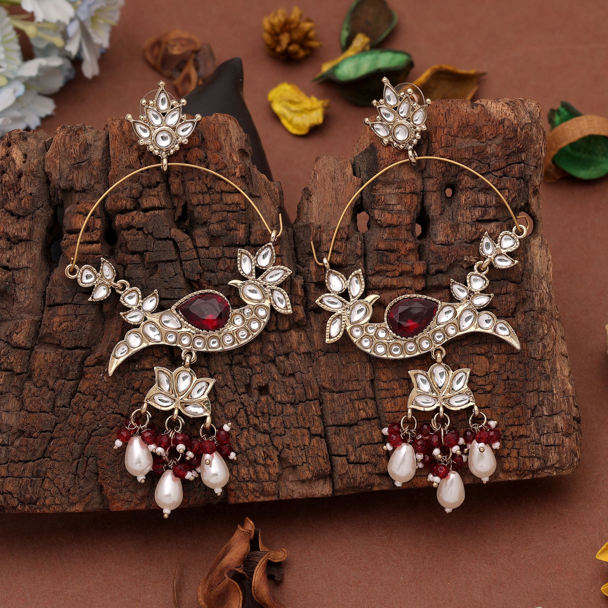 A pair of oversized antique gold-plated hoop chandbali earrings adorned with multi-shaped Kundan stones, a large central faceted gemstone, and a dangling fringe of tiny black micro-beads paired with smooth white pearl droplets.