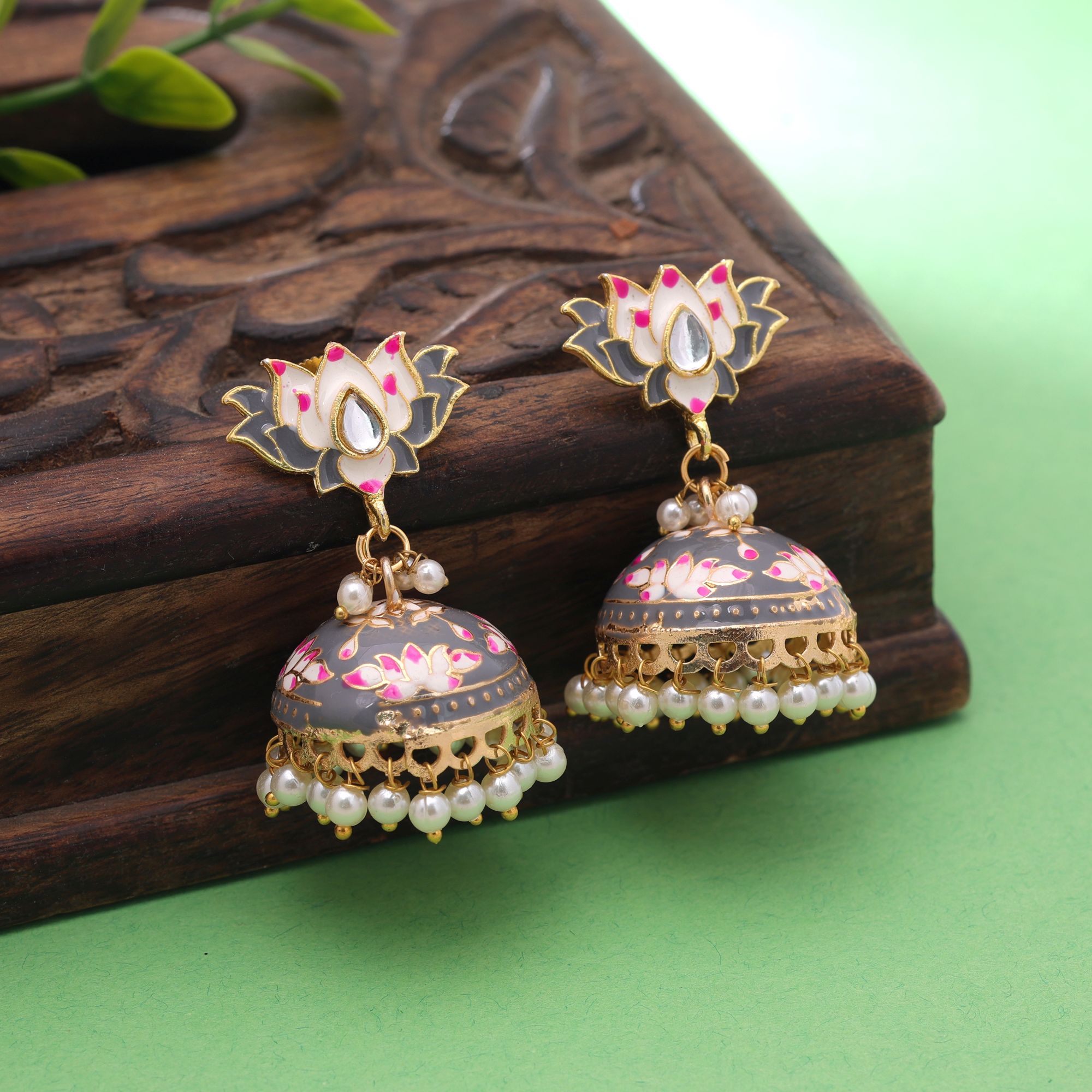 A pair of traditional gold-plated sky blue Meenakari jhumka earrings featuring an upper stud shaped like a blooming lotus flower with white and pink petals, a bell-shaped dome detailed with lotus blossoms and gold vines, and a lower fringe of dangling white faux pearl drops.