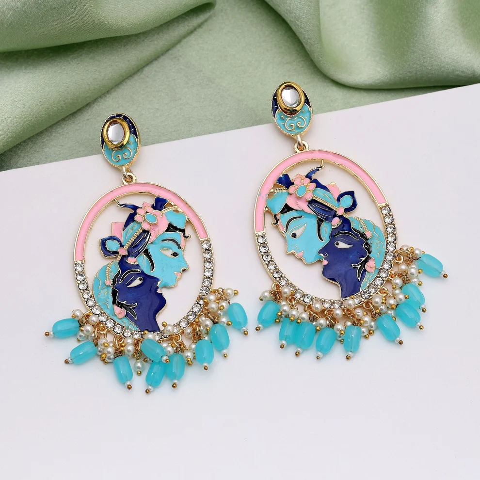 Pair of gold-tone Radha Krishna oval statement earrings with pink and turquoise enamel work, clear rhinestone accents, and a dangling fringe of small pearls and light blue teardrop beads.