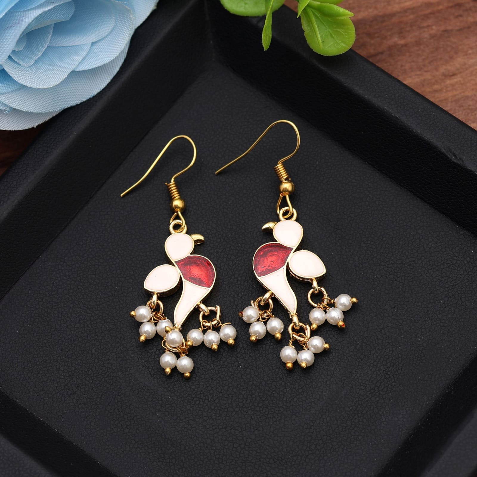 Elevate your ethnic collection with these gold-plated meenakari bird dangle earrings. Crafted in a charming bird motif accented with WHITE enamel, deep red detailing, and delicate white pearl cluster drops, this handcrafted pair brings traditional Indian flair and modern charm to festive outfits, weddings, and casual traditional wear.
