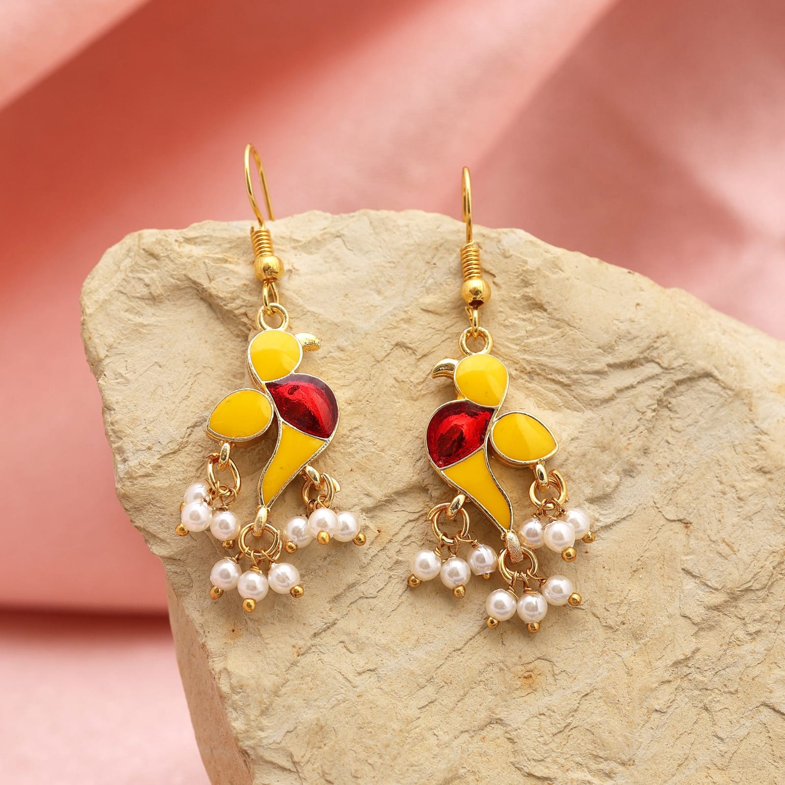 Pair of gold-plated fish-hook dangle earrings featuring vibrant yellow and red enamel bird design with dangling white pearl clusters.